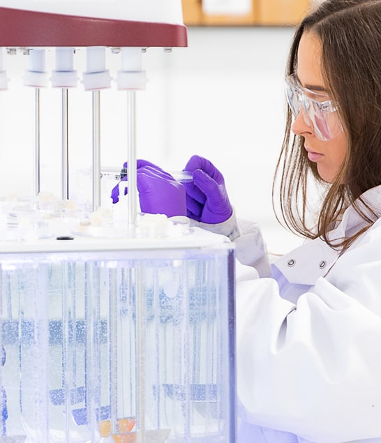 Close up of scientist wearing safety goggles carrying out work in a lab