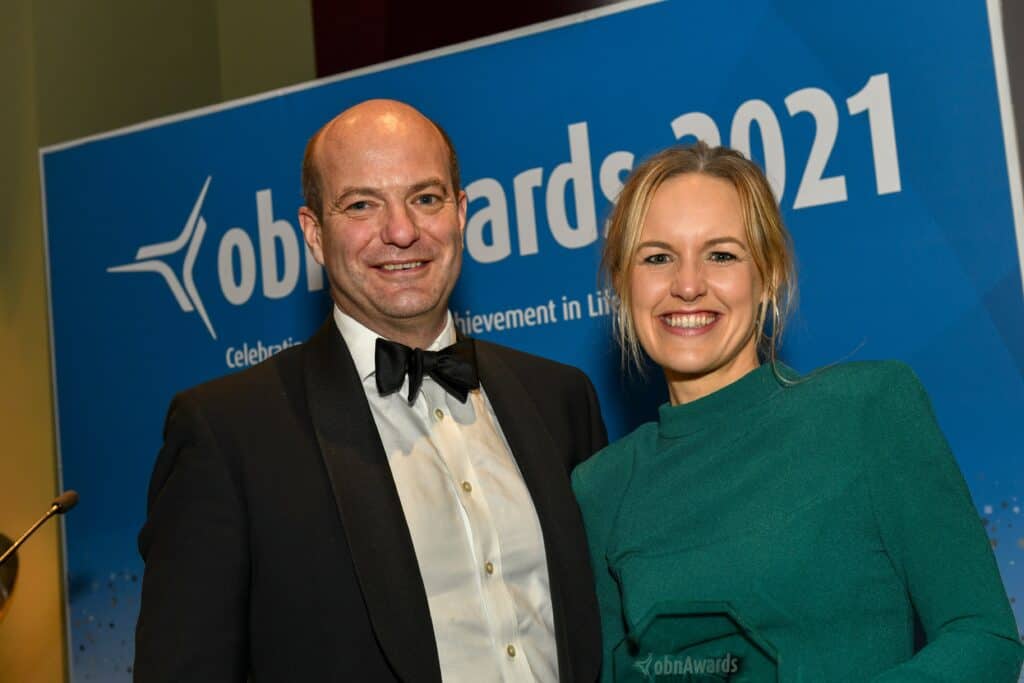 Claire Patterson and Colin McCall standing in front of OBN Awards with Best CRO Trophy